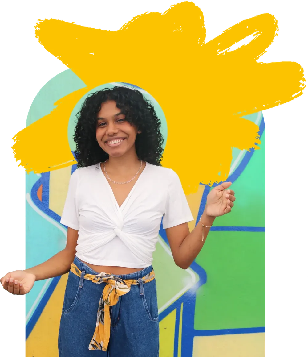 Jovem da Despertar sorrindo diante de um muro grafitado